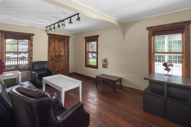 Living room with wood-type flooring, baseboards, rail lighting, and plenty of natural light | Image 6