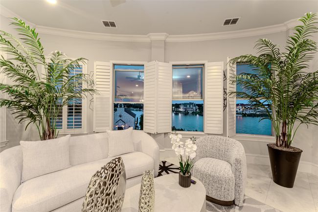 Living area with crown molding and a water view | Image 15