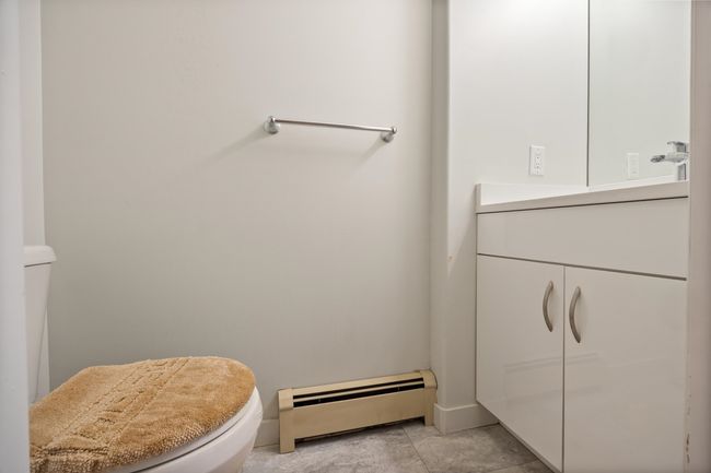 Half bath featuring vanity, toilet, and a baseboard heating unit | Image 23