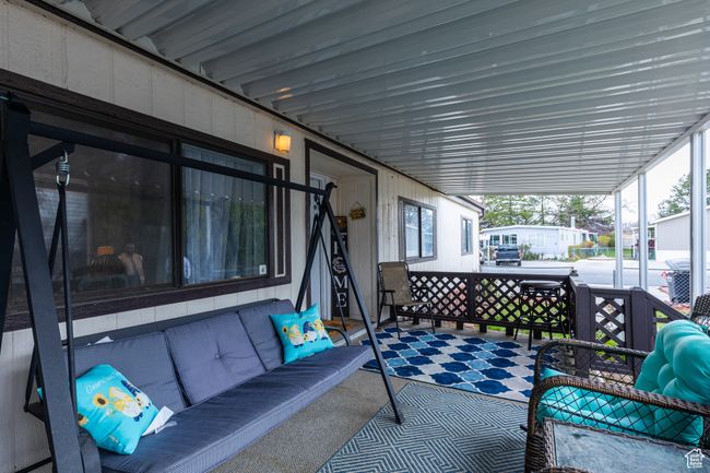 View of patio featuring an attached carport and an outdoor hangout area | Image 22