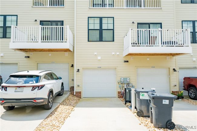 Rear view of property with a balcony, an attached garage, and driveway | Image 47