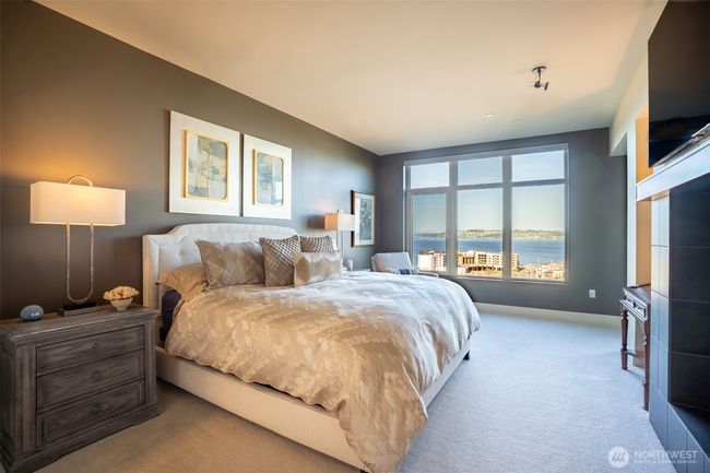 The primary bedroom will be your own personal retreat as you enjoy the other side of the dual sided fireplace and complimentary views of Commencement Bay. | Image 10