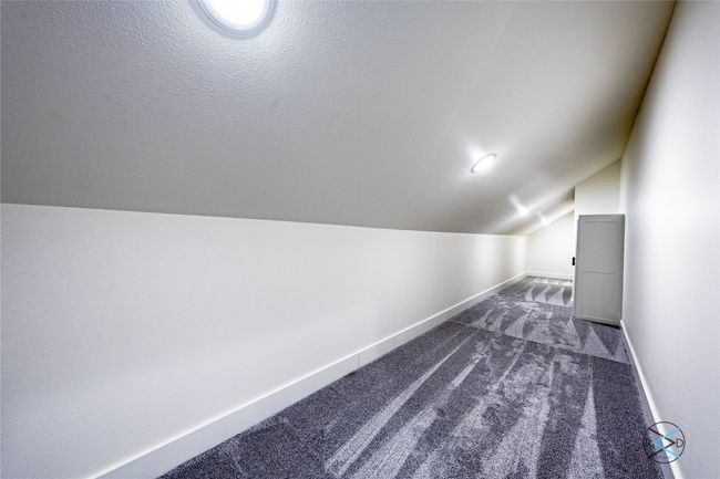 Additional living space with vaulted ceiling, a textured ceiling, and dark colored carpet | Image 20