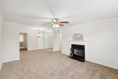 Living room and Dining room openness offer fireplace with gas logs. Freshly painted and new carpet. This area also offers 2 closets. | Image 1