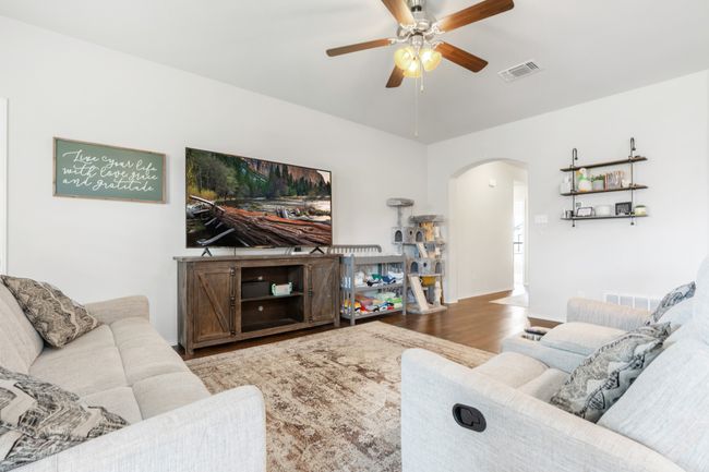 Living area featuring arched walkways, ceiling fan, and wood finished floors | Image 14