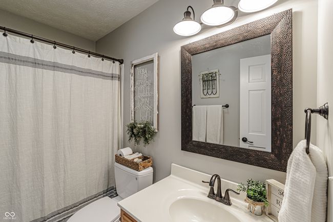 bathroom featuring a textured ceiling, toilet, vanity, and a shower with curtain | Image 17