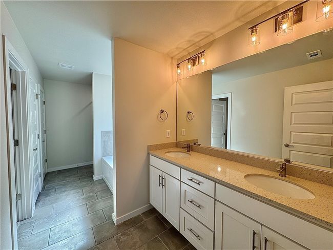 Pamper yourself in the lavish master bathroom, featuring a generously sized walk-in shower that envelops you in a cascade of soothing water or relax in the tub, while the double sinks provide ample space for personal care routines and a touch of modern elegance. | Image 11