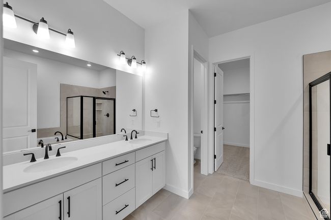 Full bath with a shower stall, double vanity, toilet, recessed lighting, and baseboards | Image 14