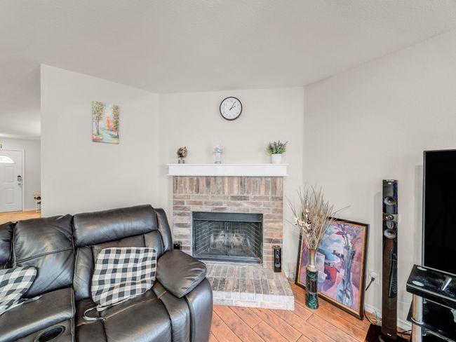 Living area featuring wood finished floors and a brick fireplace | Image 6