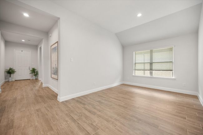 Spare room with light wood-type flooring, recessed lighting, and lofted ceiling | Image 25