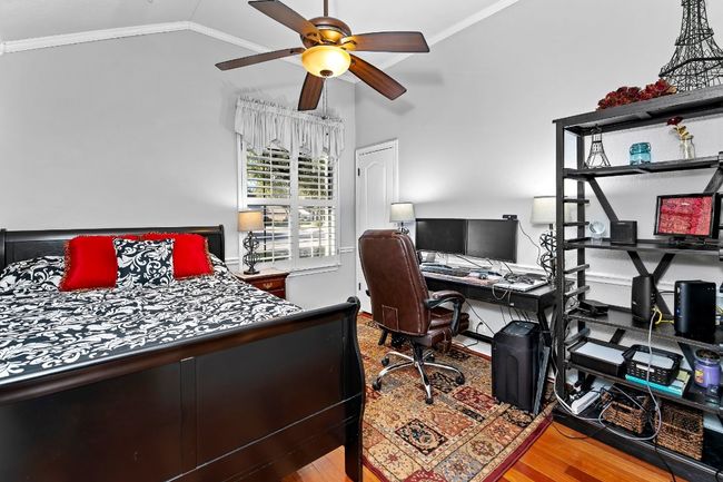 Bedroom with crown molding, vaulted ceiling, light wood-type flooring, and ceiling fan | Image 20