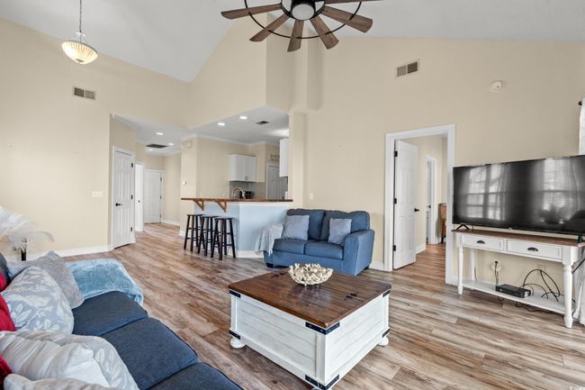 Living area featuring baseboards, light wood-style flooring, visible vents, and a ceiling fan | Image 6