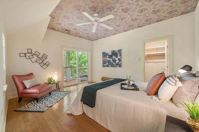 The primary bedroom offers a spacious retreat, with a beautiful ceiling accent and enough room for a king-sized bed and a cozy reading nook | Image 19