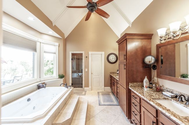 The primary ensuite features double vanity sinks, a separate walk-in shower, and a luxurious bathtub complete with a view! | Image 22