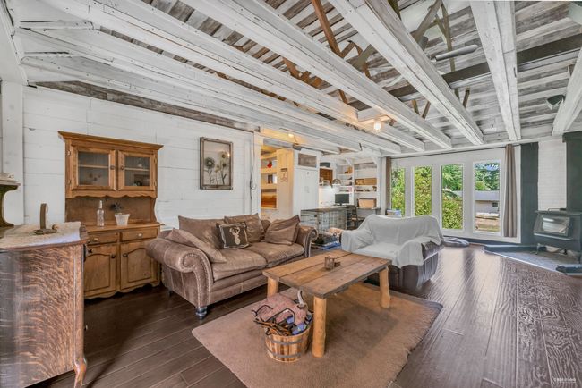 Living room with dark wood-style flooring and a wood stove | Image 22