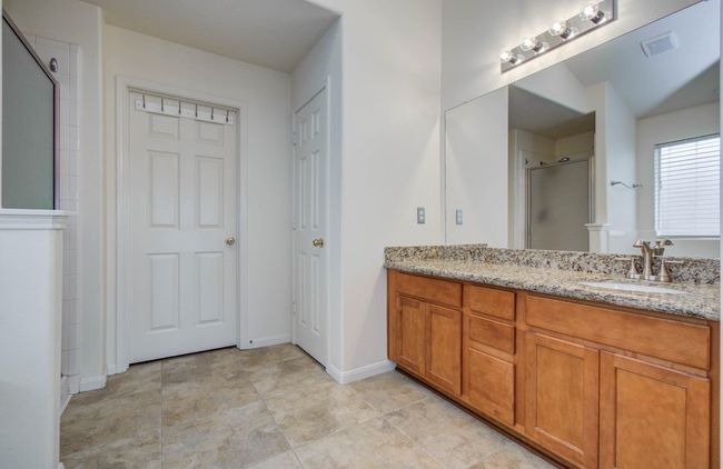 Primary bathroom has large vanity with under cabinet storage. | Image 22