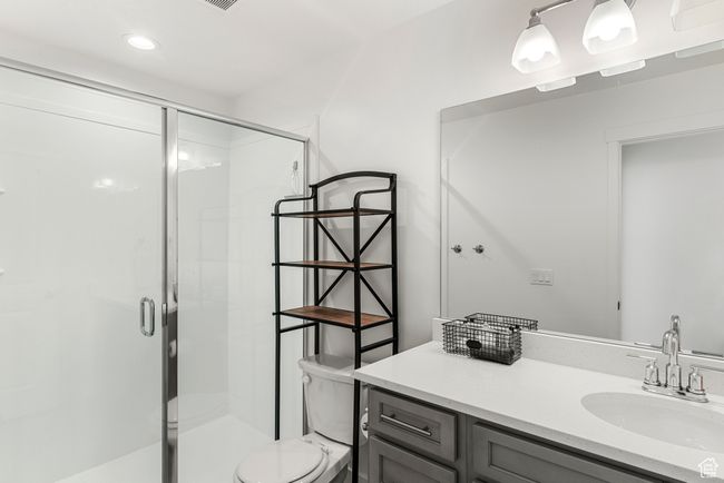 Full bath featuring recessed lighting, a shower stall, toilet, and vanity | Image 23