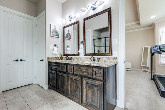 Full bath featuring double vanity, ornamental molding, and a shower with shower door | Image 23