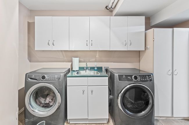 Washroom featuring washing machine and dryer and cabinet space | Image 36