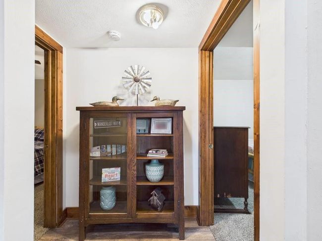 Hall with a textured ceiling and carpet floors | Image 54