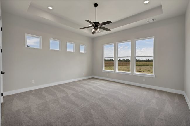 Unfurnished room featuring a raised ceiling, light carpet, a ceiling fan, and recessed lighting | Image 16