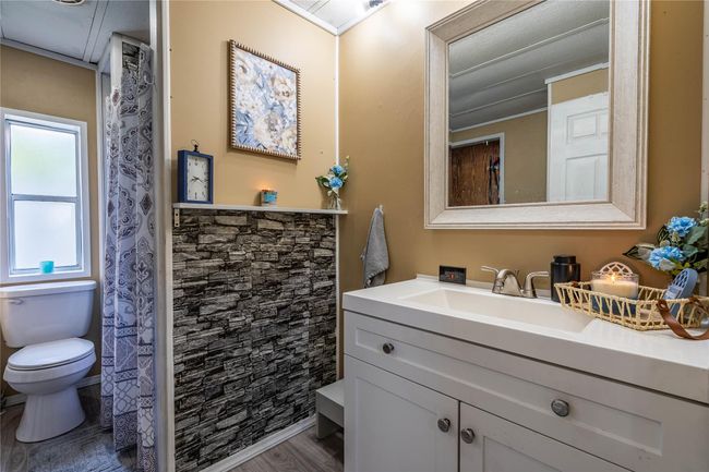 Bathroom featuring toilet, vanity, and wood finished floors | Image 11