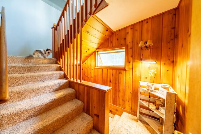 Stairs featuring vaulted ceiling and wooden walls | Image 15