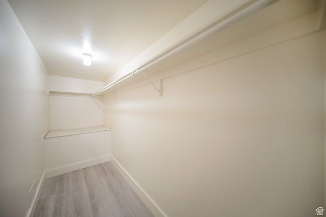 Spacious closet with light hardwood / wood-style floors | Image 12