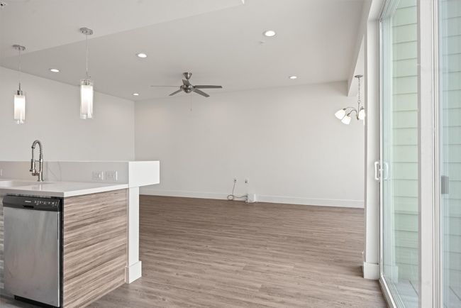 Kitchen with stainless steel dishwasher, wood finished floors, ceiling fan, recessed lighting, and open floor plan | Image 12