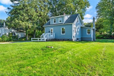 Rear view of house featuring a deck and a lawn | Image 1