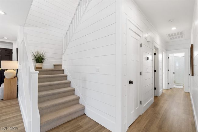 Hall featuring light wood finished floors, stairs, visible vents, and recessed lighting | Image 7