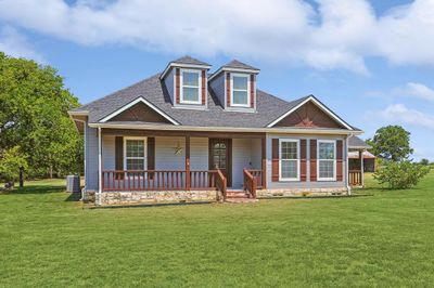 View of front of house with cooling unit, a porch, and a front yard | Image 1