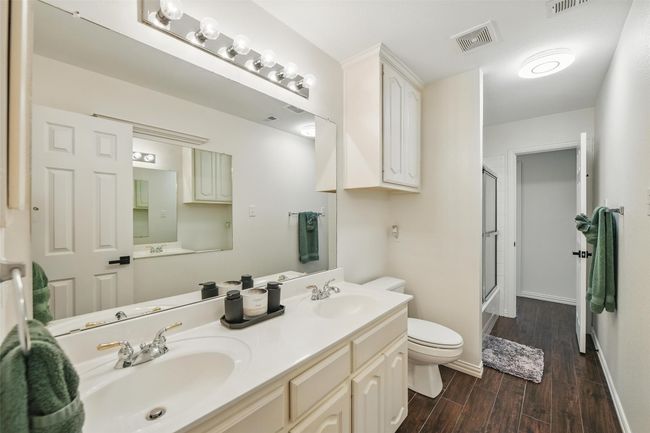 Full bath featuring an enclosed shower, wood finished floors, and double vanity | Image 24