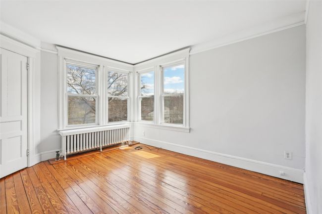 Spare room with radiator heating unit, wood-type flooring, ornamental molding, and baseboards | Image 19