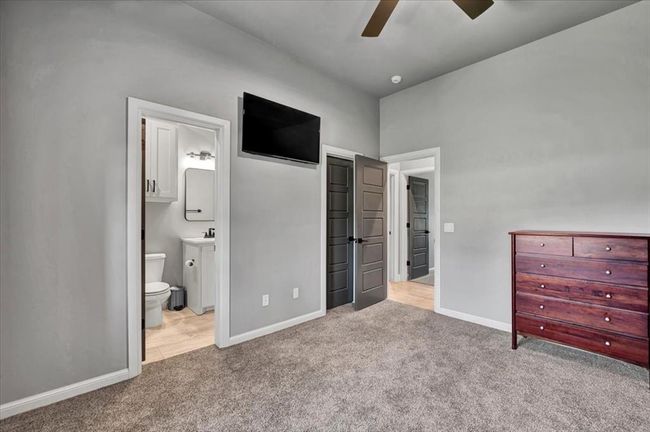 Unfurnished bedroom with carpet flooring, baseboards, ensuite bathroom, and a sink | Image 38