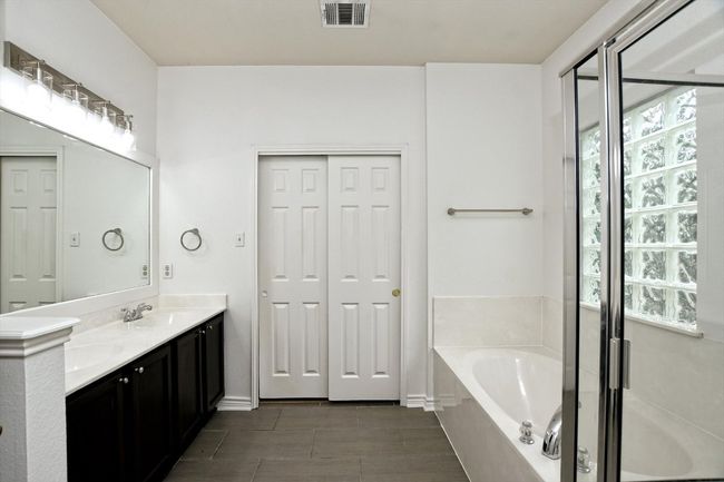 Full bathroom featuring a bath, double vanity, and a shower stall | Image 13