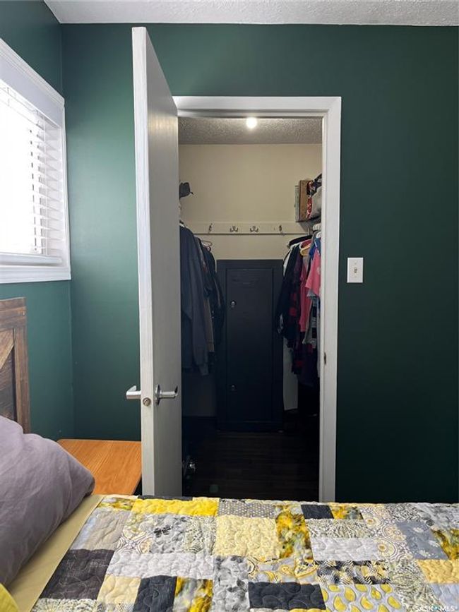 Bedroom featuring a fireplace, a closet, wood finished floors, and a textured ceiling | Image 31