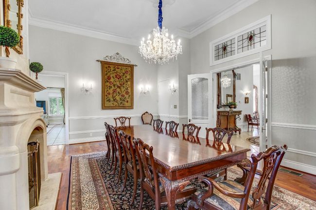 Dining room with a chandelier, a towering ceiling, wood finished floors, and ornamental molding | Image 14
