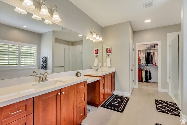 Bathroom featuring visible vents, a sink, a shower stall, and double vanity | Image 18