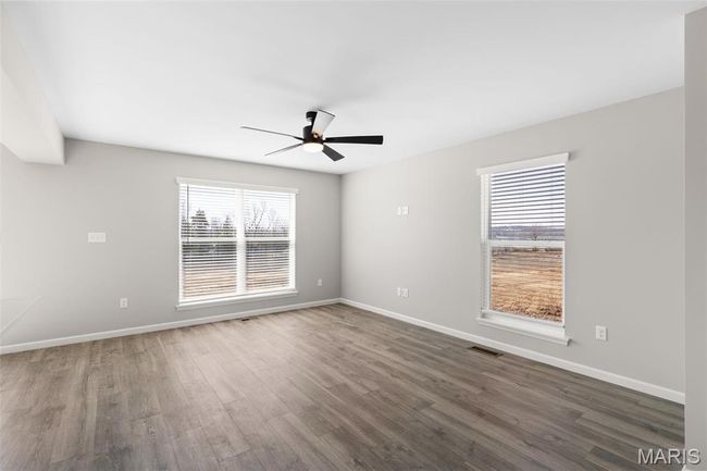 Empty room with ceiling fan, wood finished floors, and baseboards | Image 5