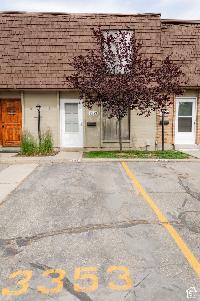 Exterior space featuring mansard roof, brick siding, and uncovered parking | Image 32
