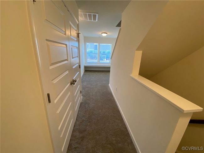 Hall featuring dark colored carpet and baseboards | Image 17