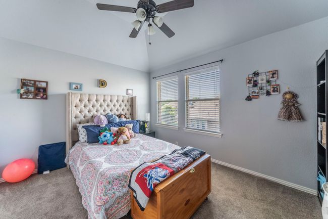 Bedroom with carpet flooring, lofted ceiling, baseboards, and a ceiling fan | Image 16