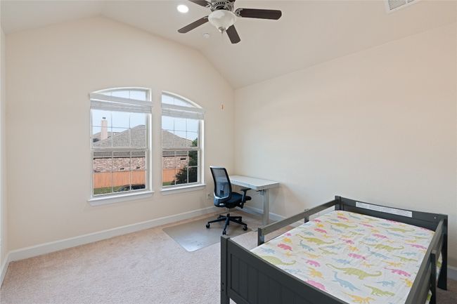 Carpeted bedroom with multiple windows, vaulted ceiling, and a ceiling fan | Image 29