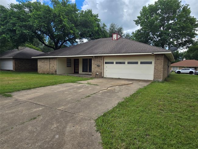 Ranch-style home with brick siding, driveway, a garage, and a front lawn | Image 23