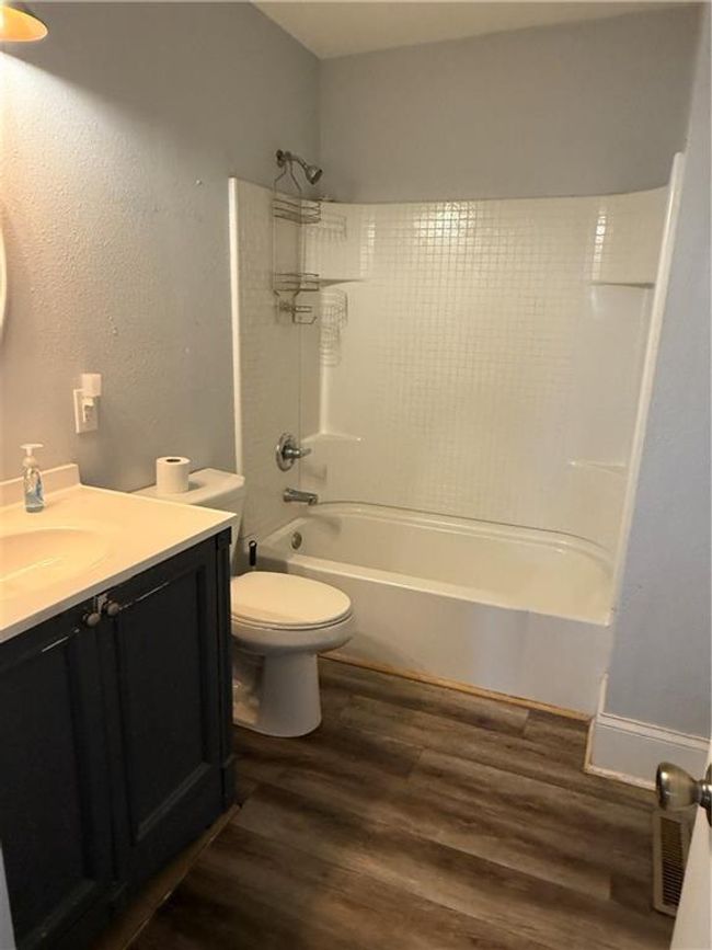 Bathroom featuring vanity, wood finished floors, shower / bath combination, and toilet | Image 15