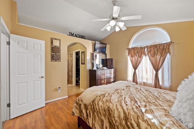Bedroom featuring lofted ceiling, a walk in closet, ceiling fan, light hardwood / wood-style floors, and a closet | Image 17