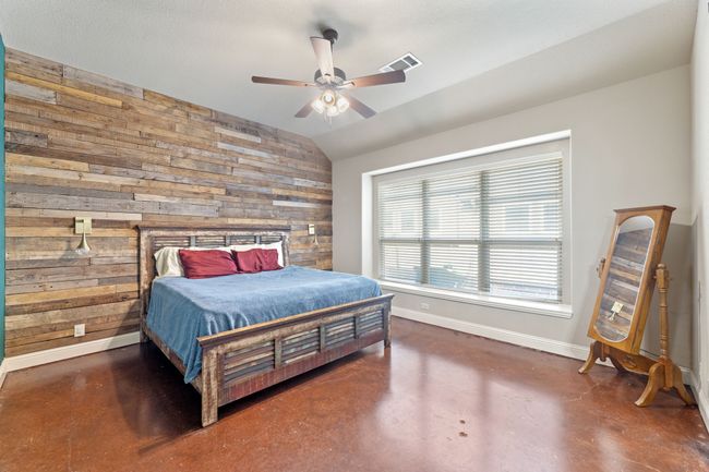 Bedroom with a ceiling fan, concrete flooring, and baseboards | Image 12