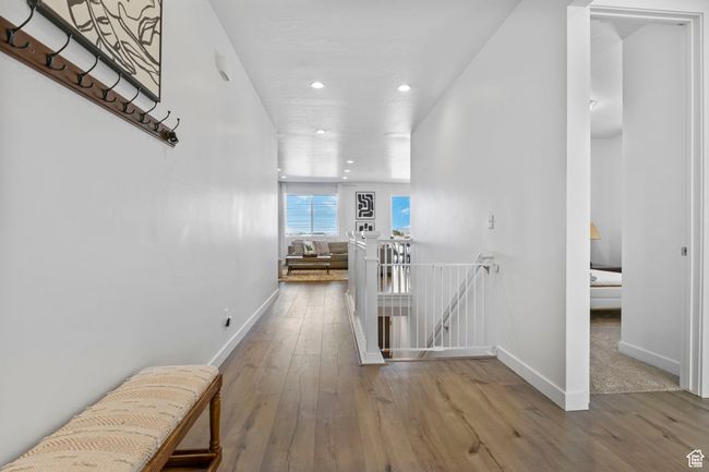 Hallway with baseboards, hardwood / wood-style floors, an upstairs landing, and recessed lighting | Image 28