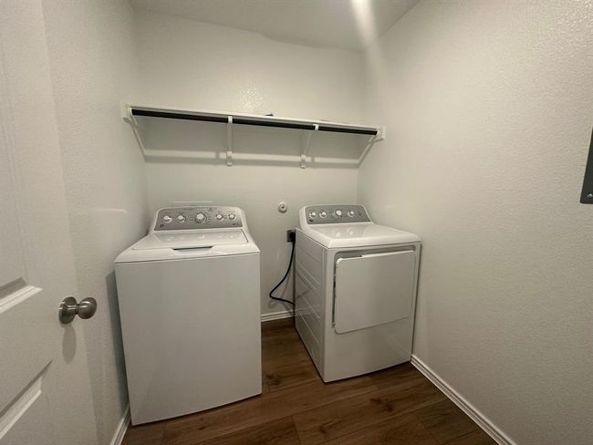 Laundry room with separate washer and dryer, dark wood-type flooring, and baseboards | Image 21